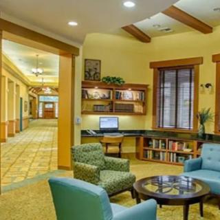 A cozy lobby area with comfortable seating, a computer desk, and a bookshelf.