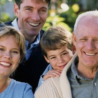 A happy family posing together outdoors, showing multiple generations.