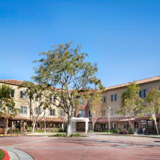 A sunny day at a modern residential building complex surrounded by trees.