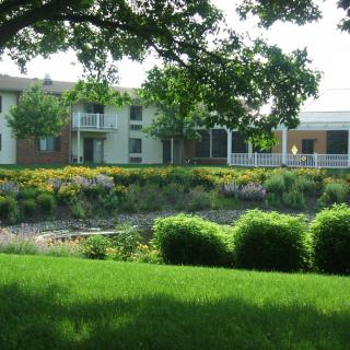 A scenic view of a building surrounded by lush greenery and gardens.