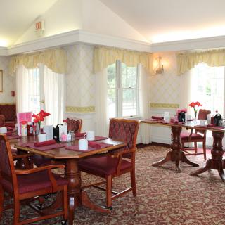A cozy dining area with elegantly set tables and comfortable seating.