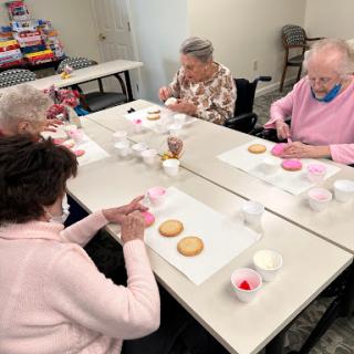 Seniors enjoying a fun cookie decorating activity together.