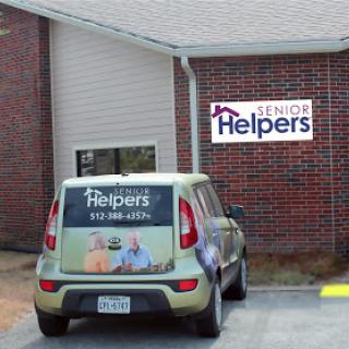 A vehicle parked in front of a Senior Helpers facility, promoting services for seniors.