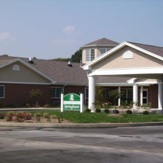 A residential building with a covered entrance and landscaped surroundings.