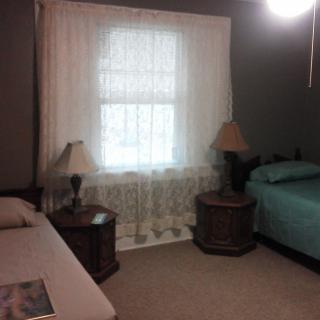 A cozy bedroom with two beds and a window adorned with curtains.