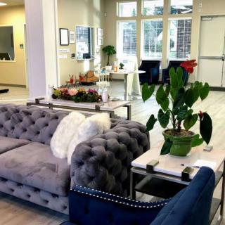 A modern living room with cozy sofas, a coffee table, and vibrant indoor plants.
