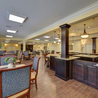 A spacious dining area with modern decor featuring multiple seating arrangements and elegant lighting.