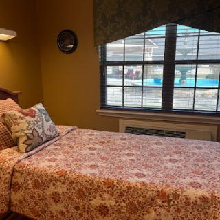A cozy bedroom featuring floral bedding and a view of the outdoors.