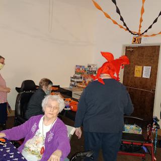 Seniors enjoying a lively celebration with festive decorations and fun hats.