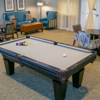 A cozy recreation room featuring a pool table and comfortable seating.