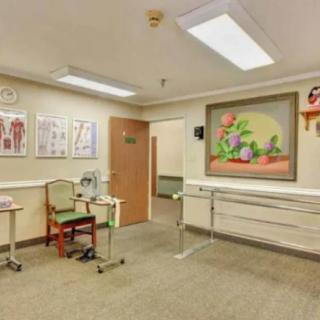 A medical office waiting room with chairs, wall artwork, and anatomical posters.