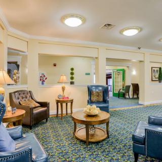 A cozy and well-decorated lobby area with comfortable chairs, tables, and warm lighting.