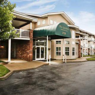 The exterior of a residential apartment building with an entrance featuring a green awning.