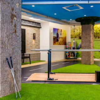 Modern indoor golf training area with simulators and putters.