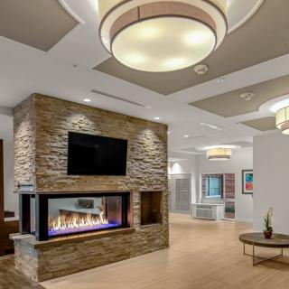 A modern living room interior featuring a stylish stone fireplace, contemporary lighting, and sleek furnishings.