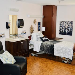 A cozy and well-designed hospital patient room featuring modern furniture and a calming atmosphere.