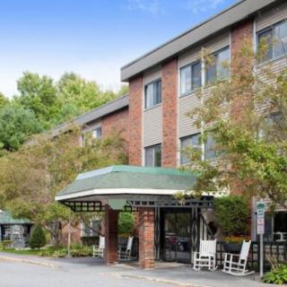 A hotel entrance with an awning and surrounding trees.
