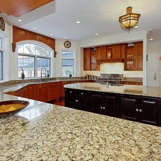 A modern kitchen with granite countertops and a central island.