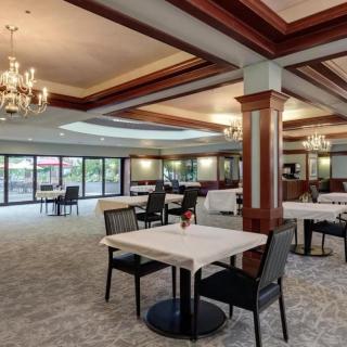 Elegant restaurant interior with dining tables, comfortable seating, and chandeliers.
