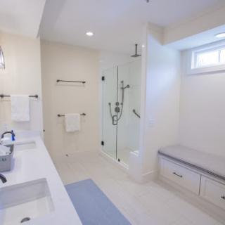 A spacious, modern bathroom featuring a glass shower and a minimalist design.
