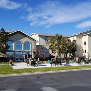 A residential building with landscaped grounds and a clear blue sky.