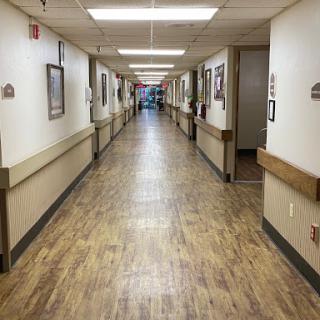 A well-lit hallway featuring artwork along the walls, typical of a medical facility.