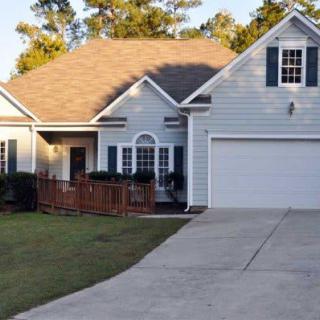 A suburban single-story house with a garage and front yard.