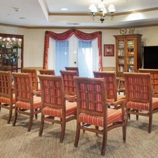 A well-arranged meeting room with multiple chairs facing a large window.