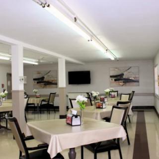 A clean and well-lit dining area with neatly arranged tables and chairs.