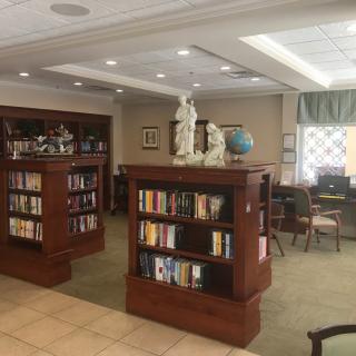 A cozy library interior with bookshelves, sculptures, and a reading area.