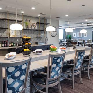 A modern kitchen with bar stools and elegant lighting.