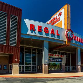 The entrance of a Regal Cinemas movie theater on a sunny day.