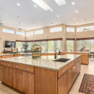 A bright and spacious modern kitchen featuring wooden cabinets and elegant granite countertops.