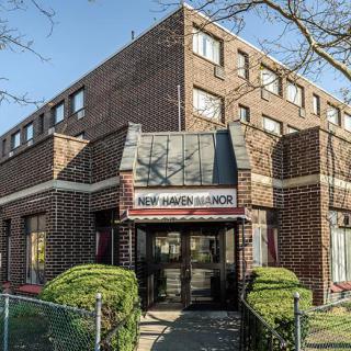 Exterior view of a brick commercial building with an entrance displaying signage.