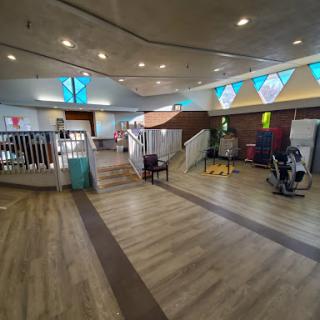 A spacious gym area equipped with exercise machines and a welcoming atmosphere.