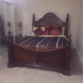 A bedroom featuring a classic wooden bed with decorative pillows.