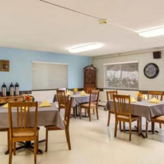 A tidy dining area with several tables and chairs arranged neatly, featuring simple decor and a calm atmosphere.