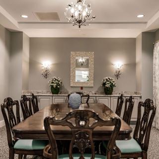 An elegant dining room with a large wooden table, chandelier, and decorative accents.