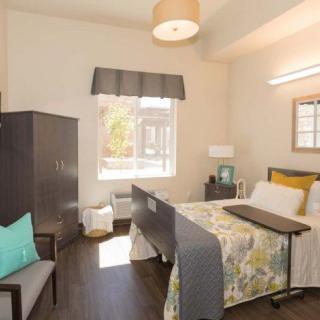 A cozy bedroom with a single bed, window, and minimalistic furniture.