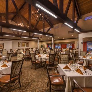 An elegant restaurant dining area with neatly arranged tables and ambient lighting.