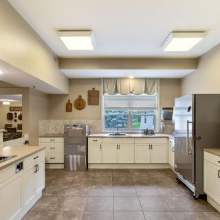A spacious modern kitchen with stainless steel appliances and tiled flooring.