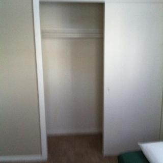 An empty closet with a sliding door in a minimalist interior.