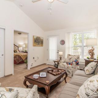 A cozy living room with a sofa set, coffee table, and decorative items in a bright and well-lit space.