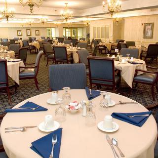 Elegantly set dining room with neatly arranged tables and classic decor.