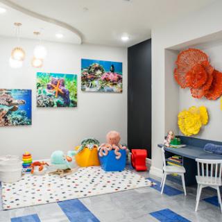 A vibrant and playful children's room featuring colorful artwork, a soft play area, and an inviting space for creativity and fun.