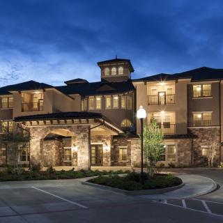 A beautifully lit building at dusk with well-maintained landscaping.