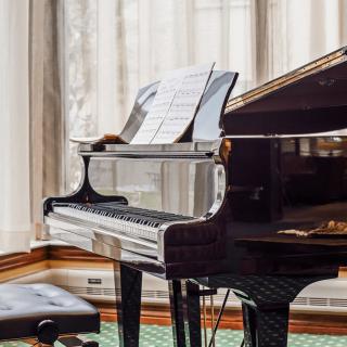 A grand piano with sheet music in an elegant room.