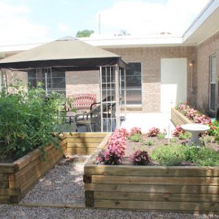 A beautiful backyard garden featuring raised flower beds and a relaxing outdoor seating area.