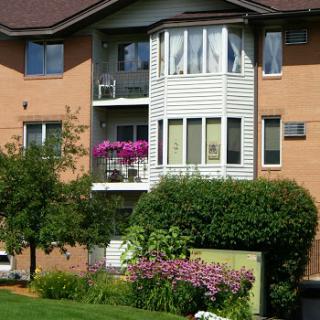 A charming residential apartment building featuring a balcony adorned with vibrant flowers.
