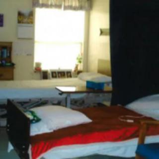 A hospital room featuring two beds and medical equipment.